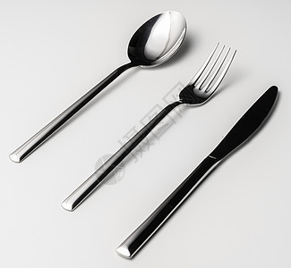 白色背景上的勺子 叉子和刀午餐剪裁反射银器用具刀具盘子金属食物桌子图片