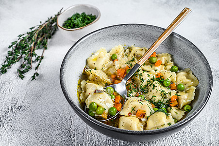 拉维奥利苏普面条 面碗里有绿色 白背景 顶层视图煮沸美食勺子香菜午餐饺子草本植物盘子食物营养图片