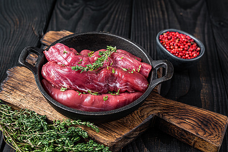 生羊肉里脊肉 乡村平底锅中的羊肉沙朗配百里香 黑色的木制背景 顶视图屠夫牛扒食物草本植物腰部木板山羊桌子盘子美食图片