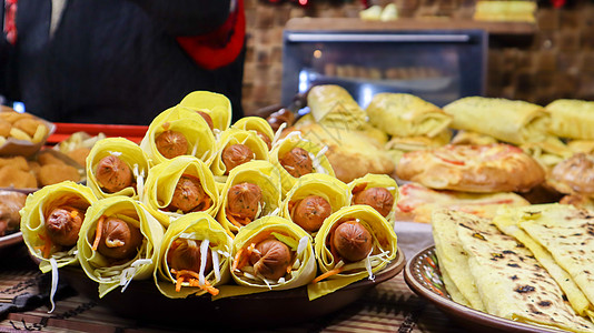 街头快餐店橱窗上的皮塔饼熏香肠 架子上放着烤香肠和热狗的托盘 街头美食节上的美食 传统食物用香肠图片