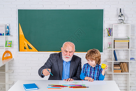 爷爷带着儿子一起学习 自信的老男老师的画像 退休年龄的概念 爷爷和儿子正在课堂上学习图片