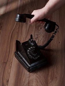 手持用木制背景保管的古董电话接收器图片