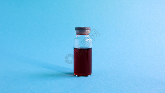 一个玻璃透明瓶 里面有红色药物 用于蓝色背景的疫苗 以医学为主题 有复制空间 针对冠状病毒流感概念的医学疫苗接种药理实验室制药生图片
