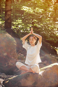 妇女在森林里沉浸在莲花的姿势中图片