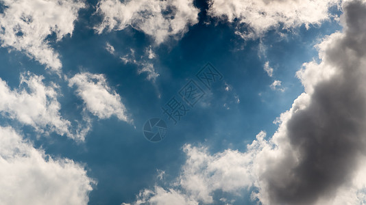 明亮的蓝天和漂浮的白云背景 剧烈的天空 雨前的天气与灰色聚集的云彩图片