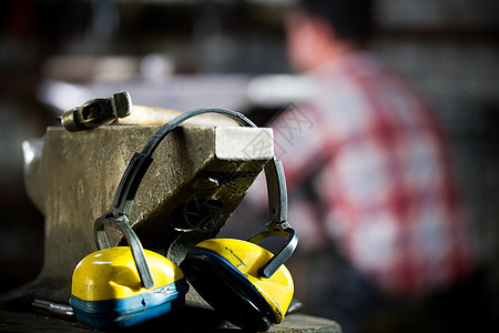 铁匠的工作空间 锤子 耳机和手套都放在保险柜上图片