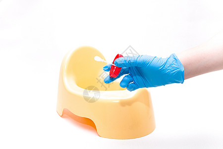 一次性蓝色医用手套里的一只手拿着一个带有白色勺子的测试罐 用于收集粪便 背景是黄色儿童锅 白色背景 复制空间塑料化学品拆除诊断排图片