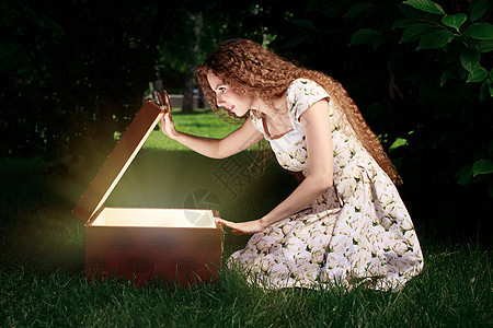 金发女孩打开神秘盒子 里面有光芒故事高清图片素材