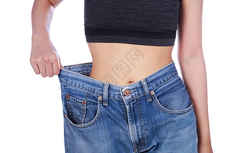 女人的特写展示了她的体重减轻 穿着白色背景中突显的旧牛仔裤重量腰部减肥成人腹部饮食女孩损失裤子身体图片