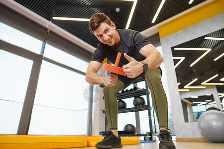 运动员运动健壮男子在健身房用滚轮机锻炼训练体育锻炼腹肌重量肌肉男人力量耐力身体地面背景