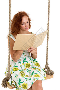 快乐的年轻女子在秋千上读书乐趣闲暇女孩微笑幸福扶手椅生活喜悦阅读成人图片