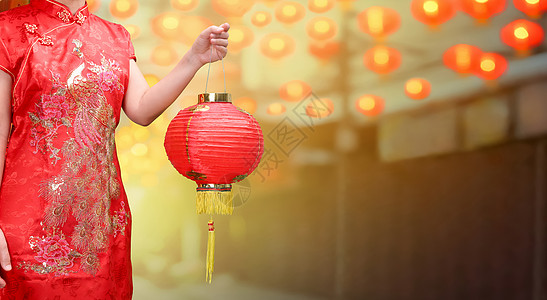 在中国城市 女人拿着中国新年的灯笼图片