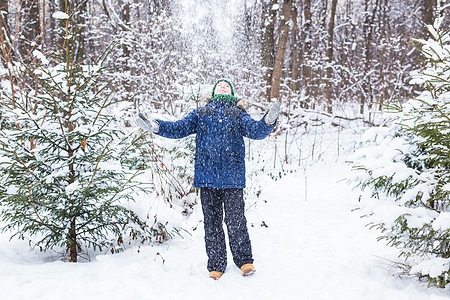 快乐的男孩扔雪 孩子 季节和冬天的概念微笑男性假期公园乐趣蓝色幸福活动闲暇快乐图片