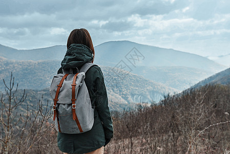 山中隐微的登山者女士享受天空爬坡道远足者生态旅游背包岩石女性游客图片