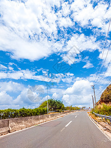 带混凝土屏障和标志线的干沥青空汽车道路 在阳光明媚的夏日 蓝云天空下铺设水泥路障和标记线图片