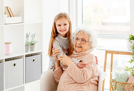抱着奶奶的小女孩眼镜拥抱孙子女性微笑家庭女孩帮助母亲老年图片