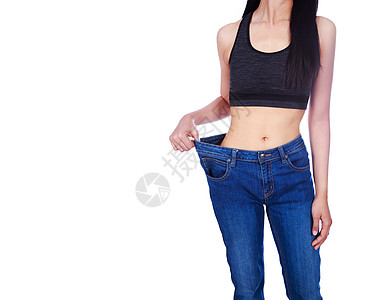 女人的特写展示了她的体重减轻 穿着白色背景中突显的旧牛仔裤成人女性损失腹部饮食身体重量腰部数字女孩图片