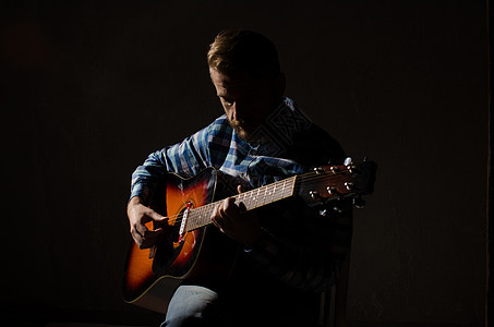 白人男性音乐家在舞台上弹吉他时的肖像 专注在手上图片