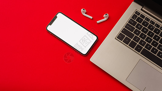 俄罗斯图拉  2019年5月24日 苹果iPhone X和用笔记本印在红色背景上的Airpod空白手机白色展示电子产品音乐气垫黑图片