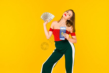 年轻女性持有钱和护照及机票 时髦女孩穿着红色上衣 穿黄色绿裤子的黄底裤 (笑声)图片