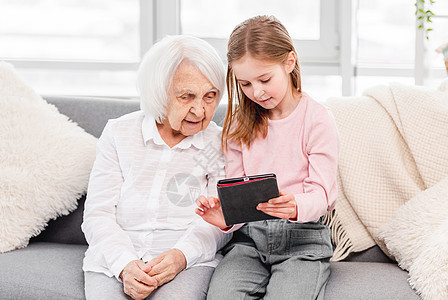 祖母 有外孙女使用平板药片女士女孩家庭奶奶老年软垫微笑闲暇祖父母女性图片