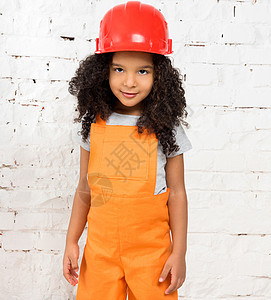 穿橙色修理工制服的小女孩工人套装肤色领班画家红色深色工作室头盔连衣裤图片