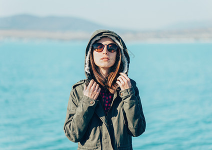 身穿夹克和海背景罩帽衫的女孩图片