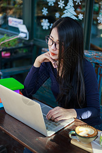 在咖啡馆用笔记本电脑工作的妇女女士杯子女孩上网学生桌子技术网络键盘酒吧图片