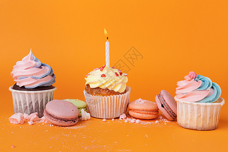 蛋糕和生日蜡烛加橙色背景糖果烘焙糕点蓝色小雨烘烤甜点小吃杯子庆典图片
