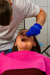 牙医在治疗牙齿问题区域之前会检查口腔女性保健牙科脸颊卫生牙疼访问手套临床工具图片