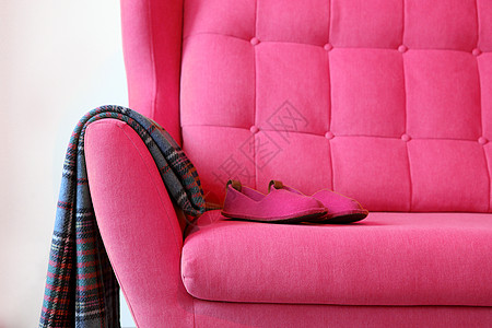 粉红色大巴上的粉红色拖鞋和毯子 客厅家庭内部的静物细节 舒适的家居内饰 家居舒适的概念 无性别的内饰 客厅的现代内饰图片