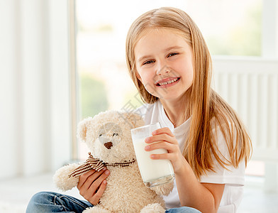 与泰迪熊拥抱的可爱女孩幸福孩子饮料眼睛微笑玩具童年婴儿动物喜悦图片