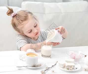 茶杯里小女孩小女孩在茶杯里倒牛奶杯子衣服桌子陶瓷仪式柠檬木头花朵茶会餐具背景