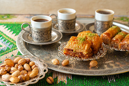 传统的阿拉伯甜甜点肉汁 加一杯咖啡土豆咖啡软糖美食金属盘子糕点桌子咖啡杯乡村蛋糕咖啡店图片