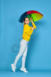 黄色雨伞披着彩彩色黄色毛衣的多色雨伞妇女青少年蓝色女士彩虹微笑街道女性喜悦潮人衣服背景