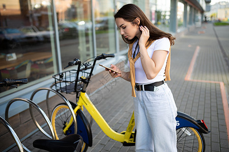 白种年轻妇女在应用程序中支付自行车租金探索休闲民众游客经济旅游旅行假期城市女性图片