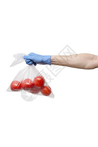手握的多柱状西红柿袋 白底上戴蓝色手套图片
