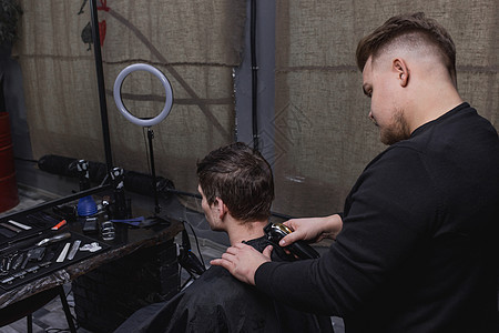 理发师或理发师用机器割下一个黑头发男的后脑勺商业理发梳子成人工作发型师男性潮人理发店男人图片