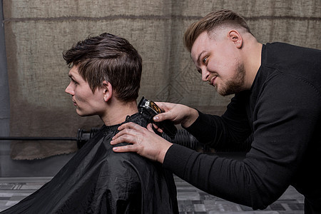 理发师或理发师用机器割下一个黑头发男的后脑勺男性发型客户梳子理发店顾客理发造型师潮人店铺图片