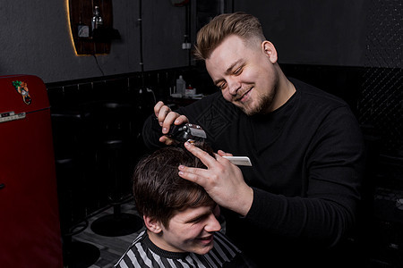 一个积极的理发师或欧洲外表的理发师在理发师里剪了一个满意的黑发客户 理发成人发型服务顾客潮人理发店梳子工作商业修剪图片