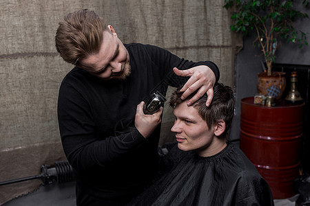 理发师或专业理发师用客户的剃须刀为黑发男士理发 理发图片