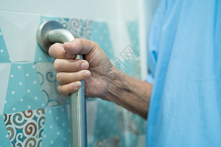 亚洲老年或老年老妇人病人在护理医院病房使用厕所浴室手柄安全 健康强大的医疗理念合金残障酒吧苗圃铁轨浴缸老年人卫生间旅馆房间图片