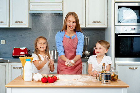 年轻金金发女孩 母亲和孩子在做饭时玩得开心面粉女儿围裙家庭乐趣童年帮手面包厨房面团图片