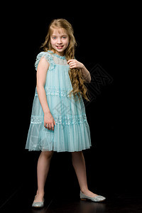 一个美丽的小女孩把头发梳在头顶上 长得一清二楚微笑女性喜悦孩子快乐裙子女儿金发理发师发型图片