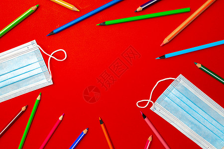 彩色铅笔和医疗面罩 大流行教育概念蜡笔口罩补给品学校面具背景图片