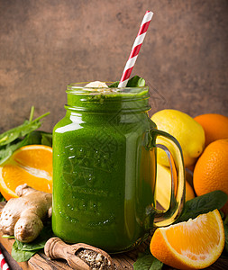 健康的绿色冰沙 玻璃罐装菠菜营养橙子果汁叶子饮料食谱桌子早餐石匠树叶图片