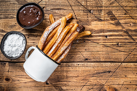 带糖和巧克力酱的Churros 木制背景 顶视图 复制空间食物甜点棕色白色油条黑色肉桂美食小吃糕点图片