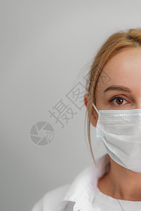 浅色背景下一位戴着医用面具的年轻金发女子的特写 病毒防护 冠状病毒 covid19 大流行病的概念 隔离 呆在家里女人医疗运输手图片
