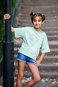服装样机站在户外台阶上的九岁女孩成人快乐样机小样喜悦服装闲暇女性双臂幸福背景