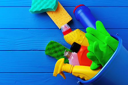 蓝木背景平地的家用清洁用品 蓝色木本底板化学品塑料清洁工瓶子卫生家政服务抹布厨房工具图片